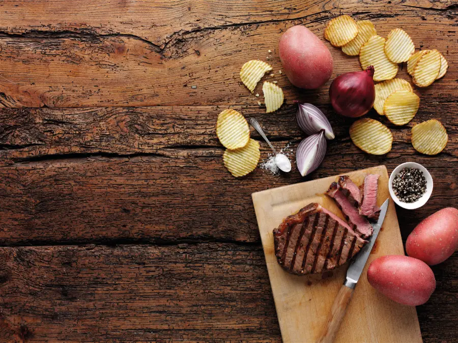 steak potatoes onions crisps wooden background