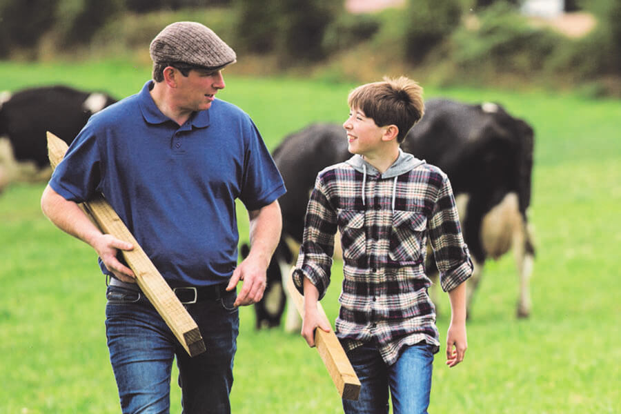 Farmer and son in a field with cows