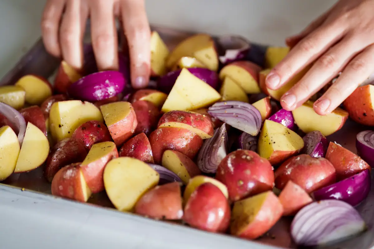 chopped potatoes and onions in baking tray