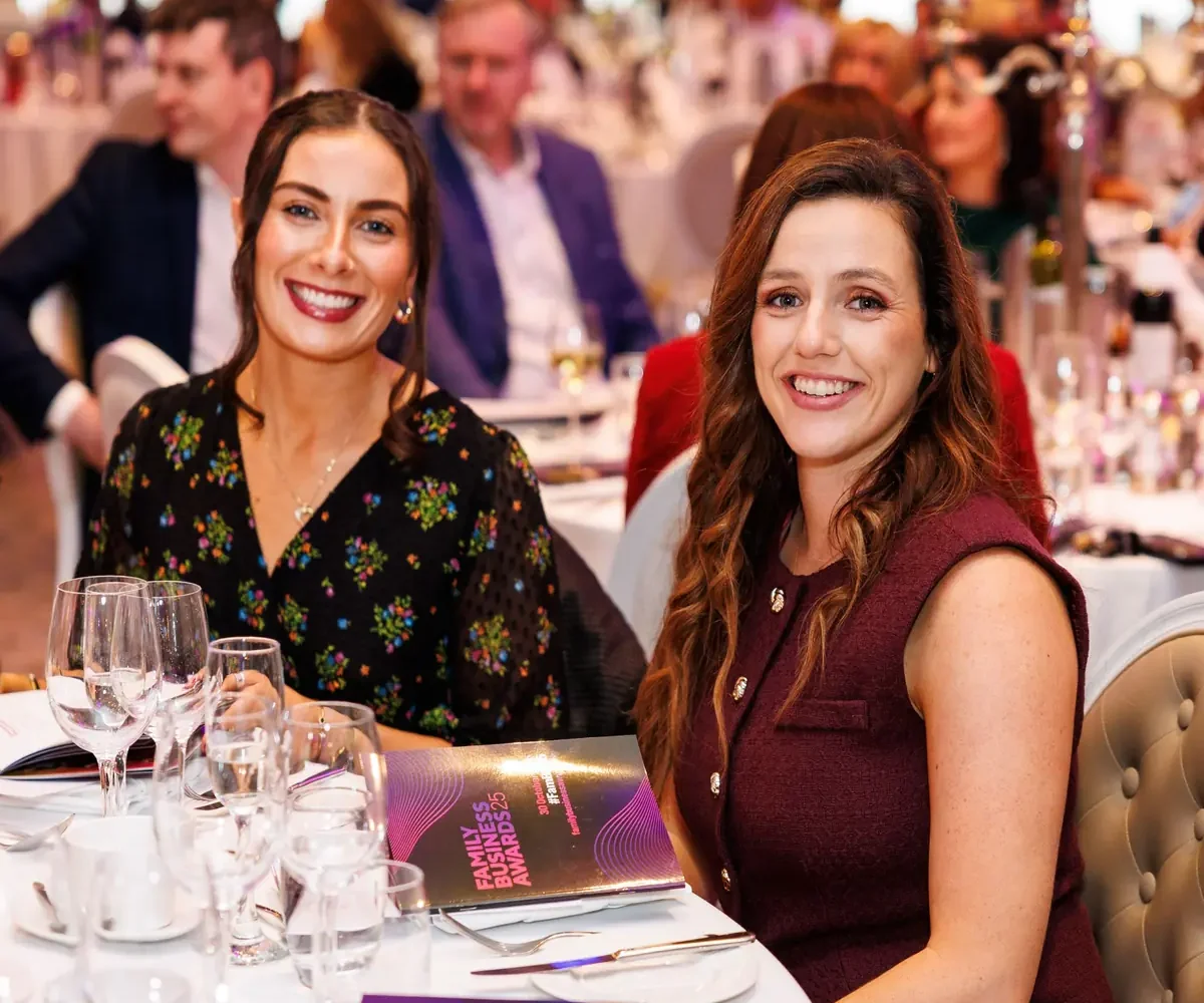 Two women smiling at awards dinner table