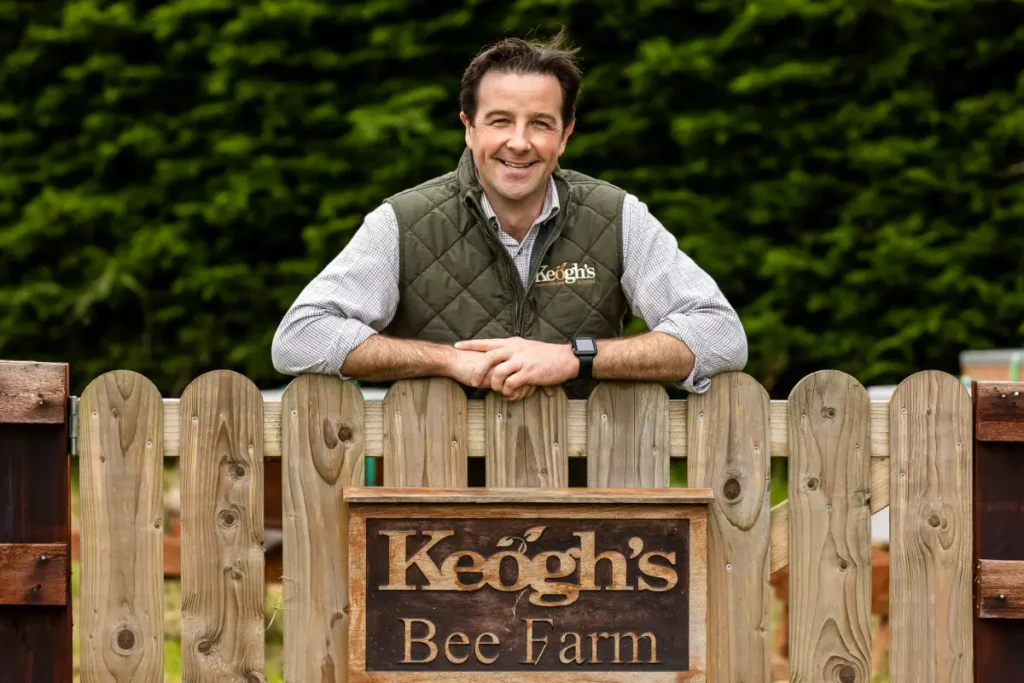man by bee farm gate wide