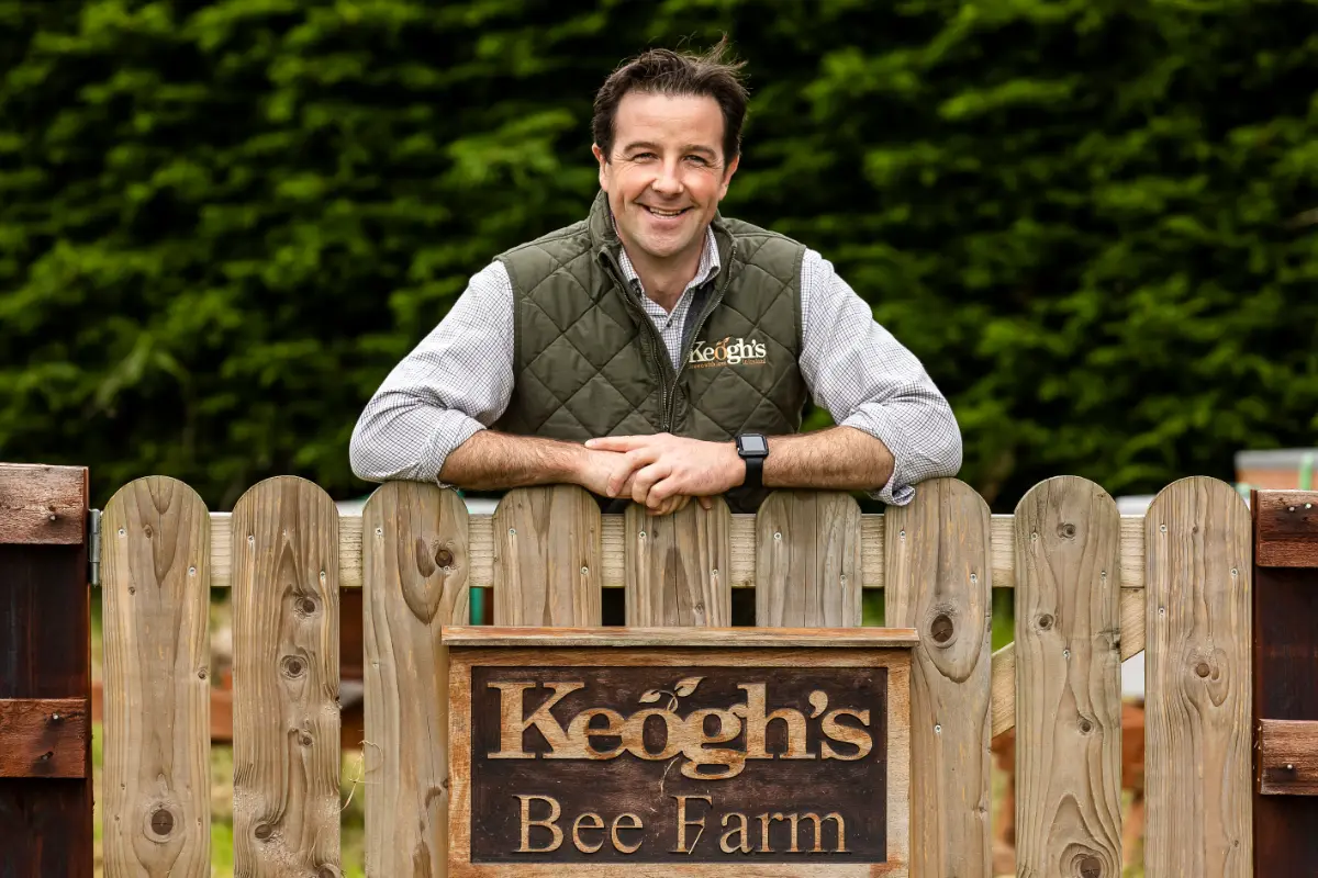 man by bee farm gate wide
