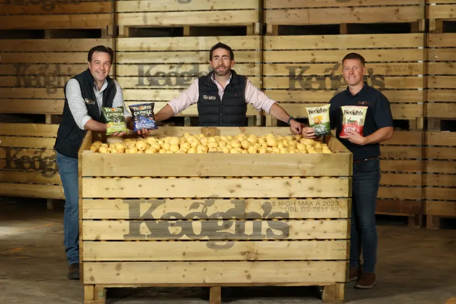 three men by wooden crate of keoghs potatoes